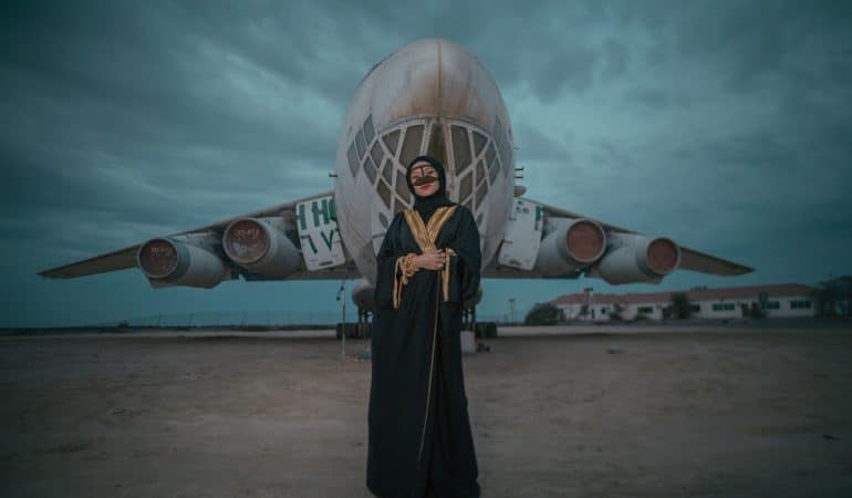 woman wearing black dress standing near white plane